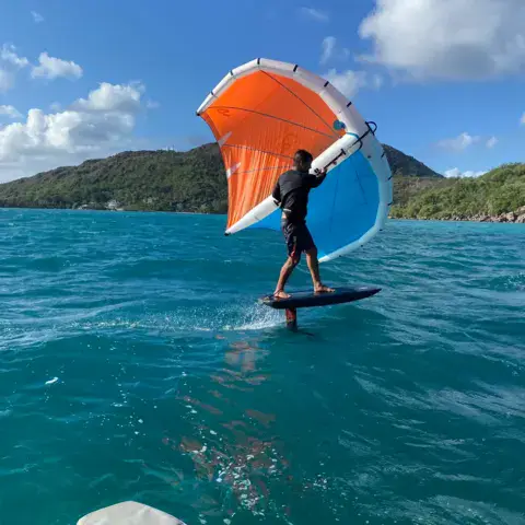 Rider en wingfoil devant la côte