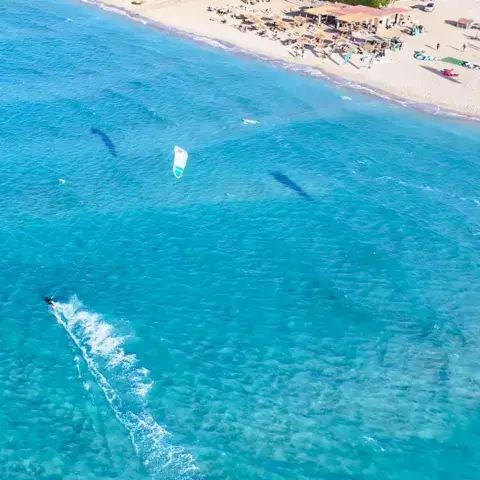 Vue aérienne de la plage et de la lagune, kitesurfeur dans son sillage