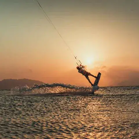 Kitesurfeur sur l'eau plate au coucher du soleil