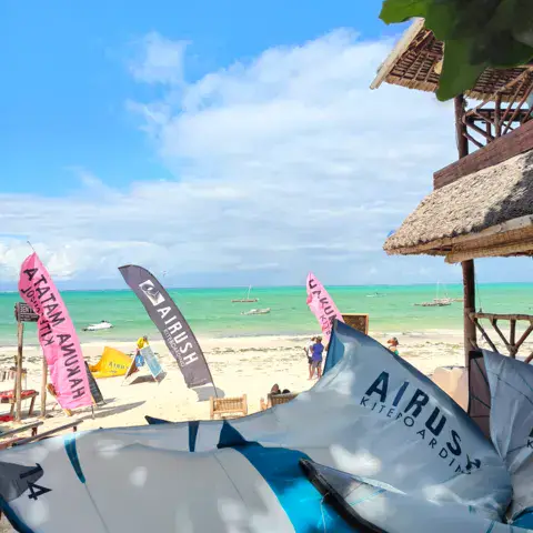 Plage de sable blanc avec ailes de kite et drapeaux