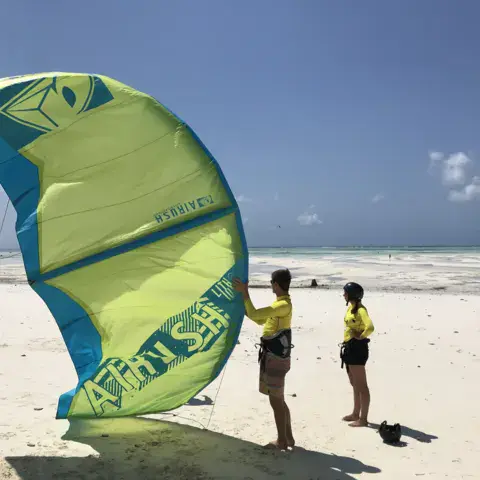 Cours de pilotage d'aile sur la plage, élèves en lycras jaunes