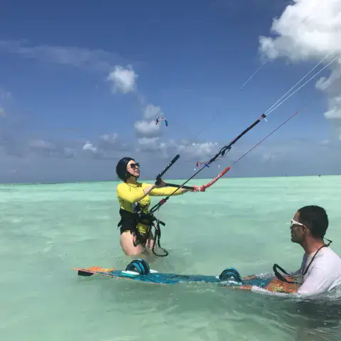 Élève en départ dans l'eau accompagné du moniteur