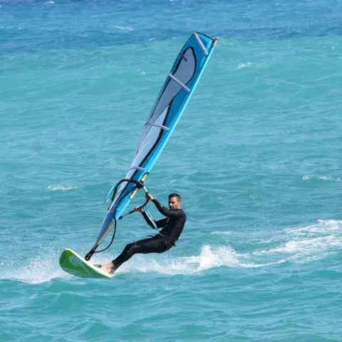 Planchiste sur une eau turquoise