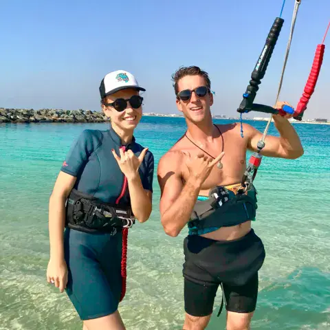 Deux personnes dans l'eau, avec une aile de kitesurf