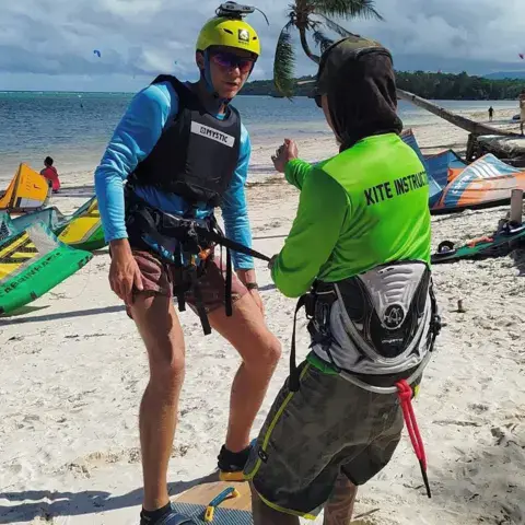 Un moniteur explique les bases à un élève sur la plage