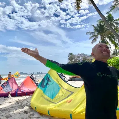 Un instructeur sur la plage devant les kites