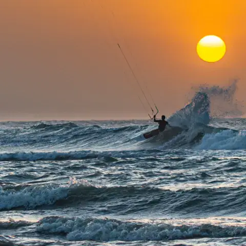 Saut de kitesurf devant le soleil couchant