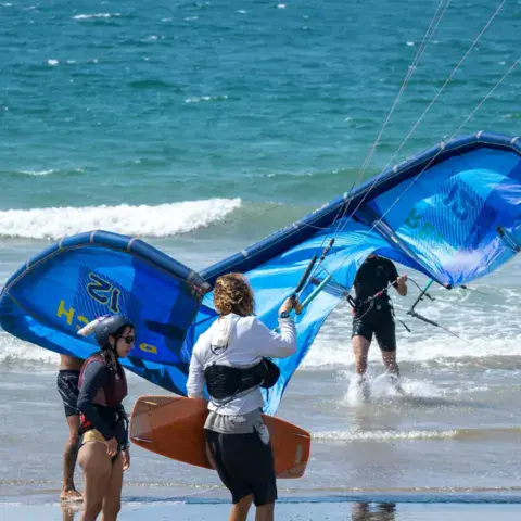 Élèves et moniteur au bord de l'eau avec une aile de kite