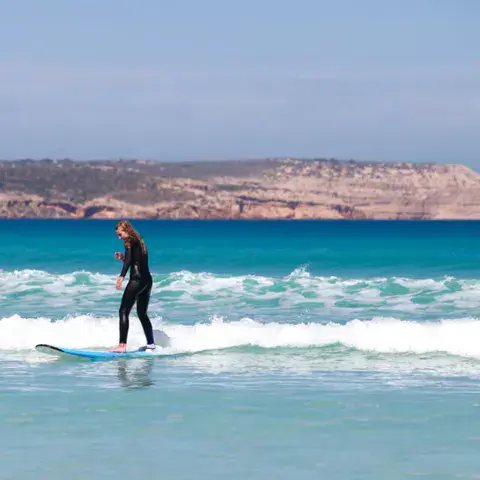 Surfeuse sur une planche mousse dans les vagues