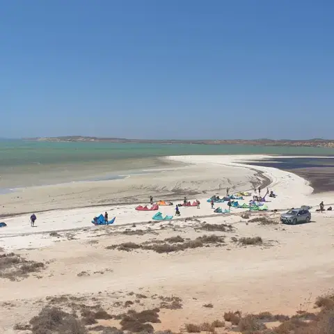 Plage de sable avec des kiters et leur matériel