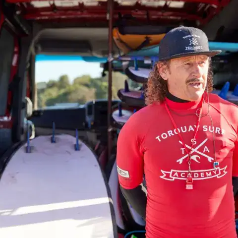 Un coach de l'école devant la camionnette à planches