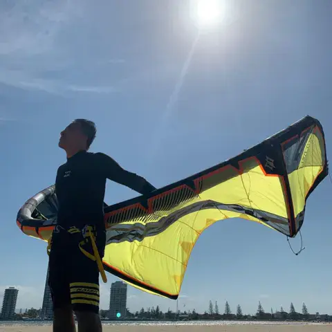 Moniteur avec une aile de kite sur la plage
