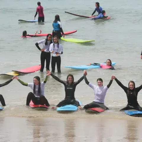 Un groupe d'élèves pendant un cours de surf