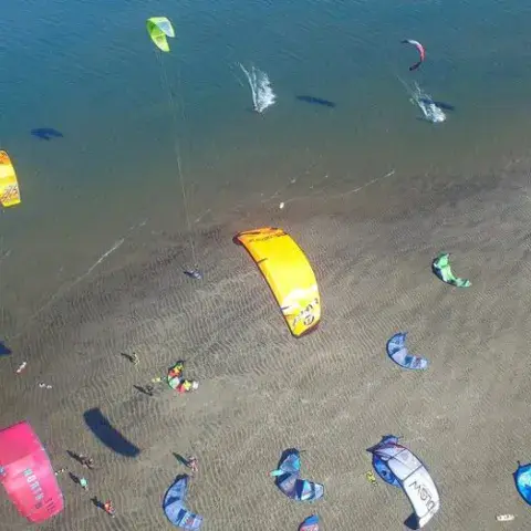Vue aérienne d'une plage avec de nombreux kites