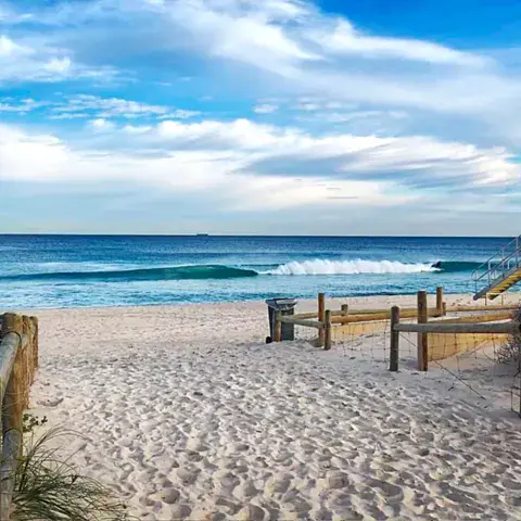 Plage de sable et vagues, poste de secours à droite