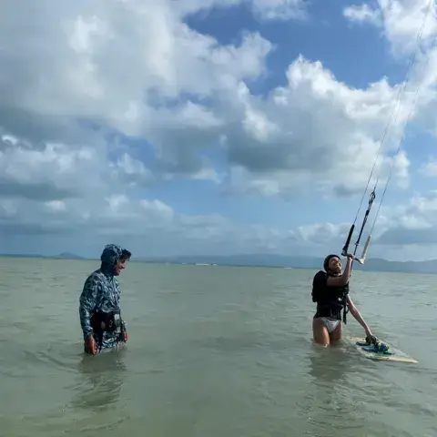 Moniteur et élève dans l'eau pendant un cours de kitesurf