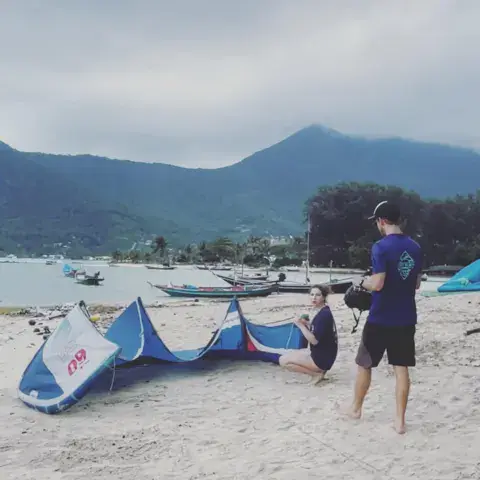 Moniteur et élève sur la plage, kites posés sur le sable