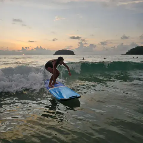 Surfeuse sur une vague à Kata Beach