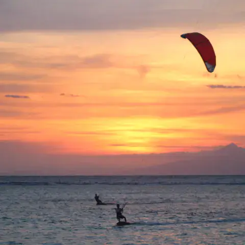 Kitesurfeurs au coucher du soleil