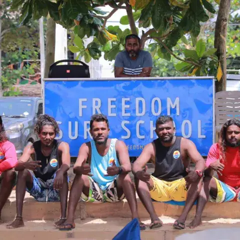 Les moniteurs de l'école assis devant leur banderole