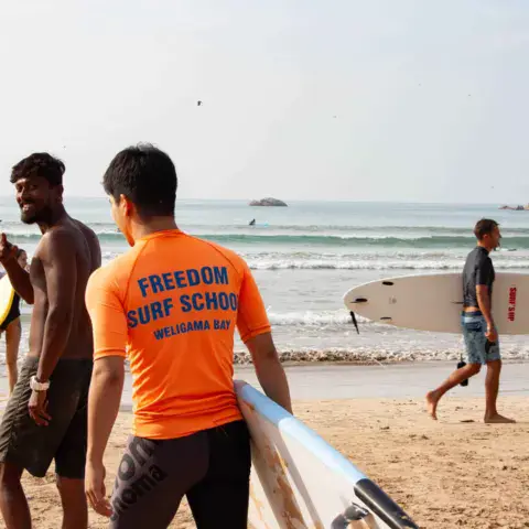 Moniteurs en tee-shirt orange sur la plage