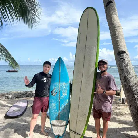 Deux surfeurs posant avec leurs planches au bord de l'eau