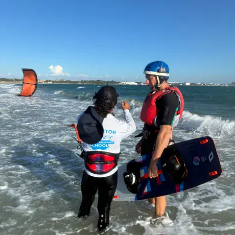 Moniteur et élève dans l'eau pendant un cours