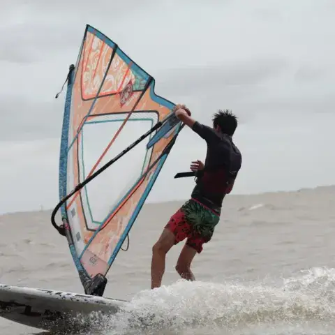 Windsurfeur sous voile sur le fleuve