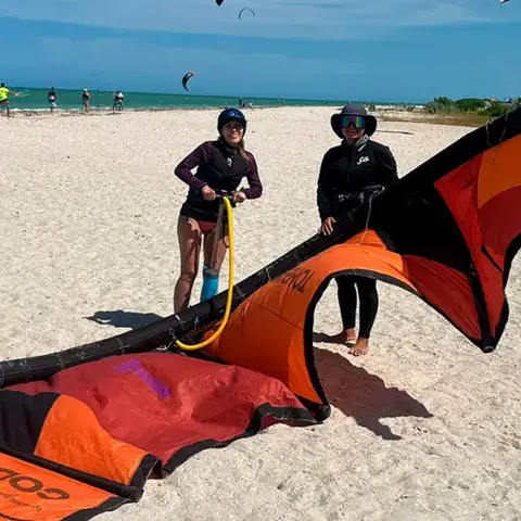 Une élève sourit avec son casque et sa planche de kitesurf