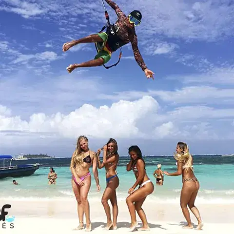 Saut de kitesurf au-dessus d'une plage de sable blanc