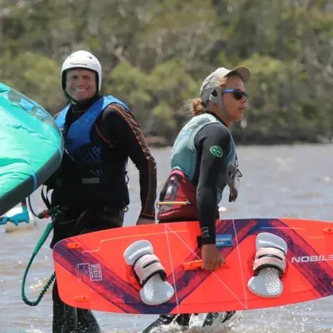 Deux élèves avec leur aile et leur planche au bord du lac