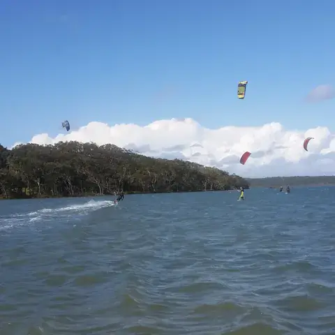 Plusieurs kitesurfeurs sur un plan d'eau abrité