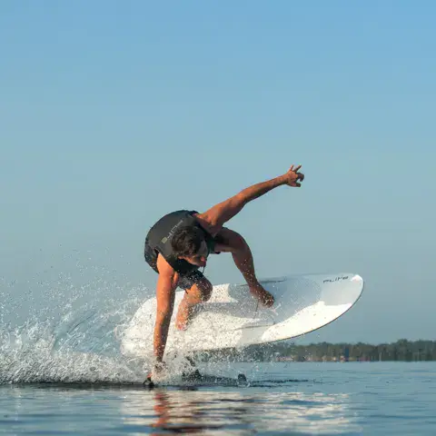 Rider sur un e-foil, gerbe d'eau à la surface