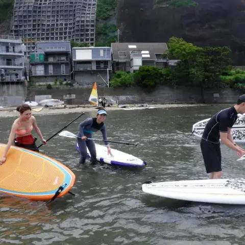 Mise à l'eau de planches de stand up paddle sur la plage