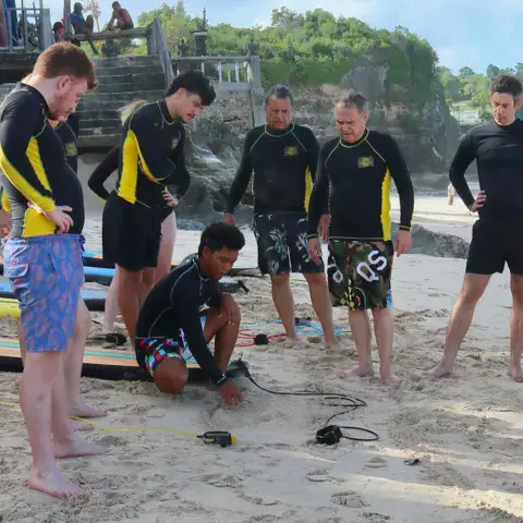 Briefing en cercle sur la plage avant le cours