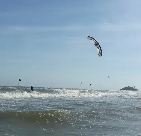 Plusieurs kitesurfeurs au large, par vent régulier
