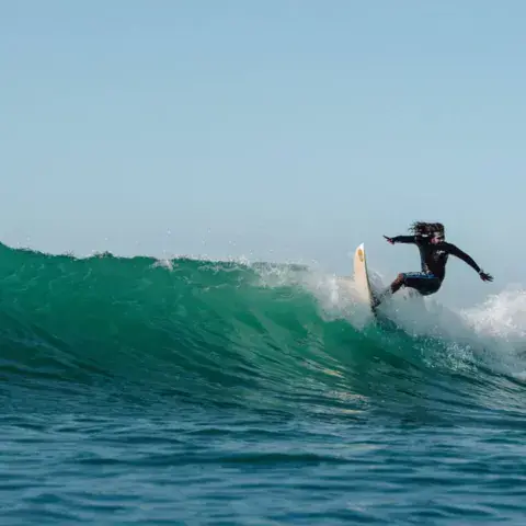Surfeur sur une vague de la baie