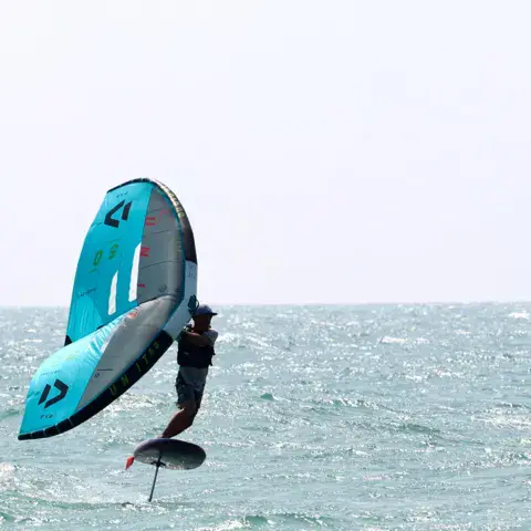 Rider de wing foil en vol au-dessus de l'eau