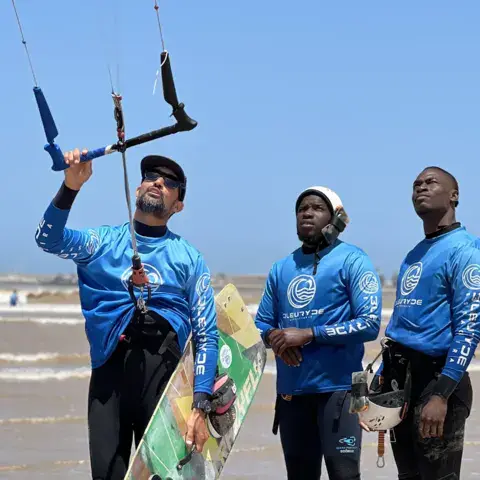 Moniteurs et élèves au briefing avant une session de kitesurf