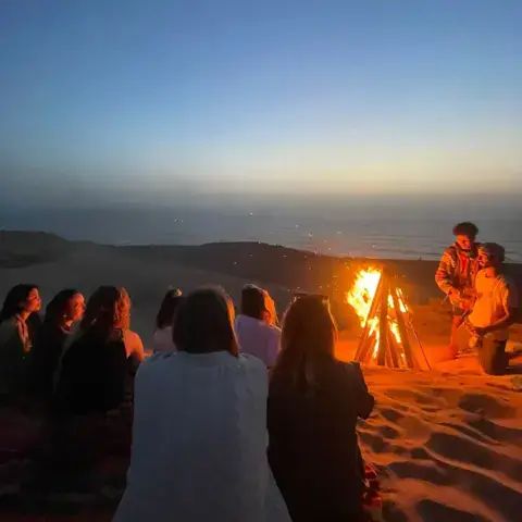 Soirée autour d'un feu de camp dans les dunes