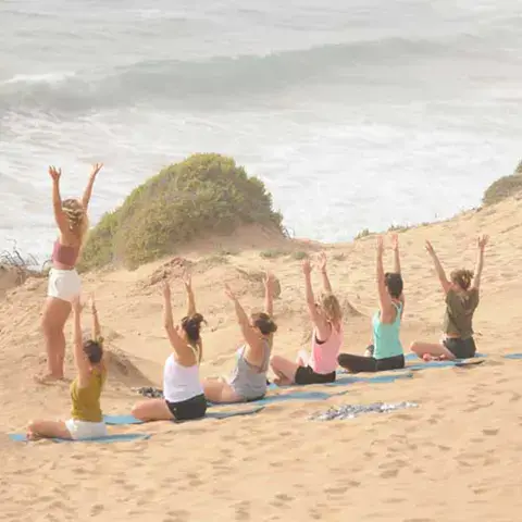 Séance de yoga sur une dune face à l'océan