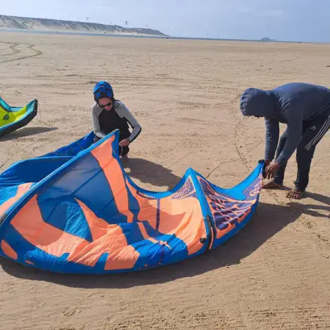 Préparation des ailes de kitesurf sur la plage