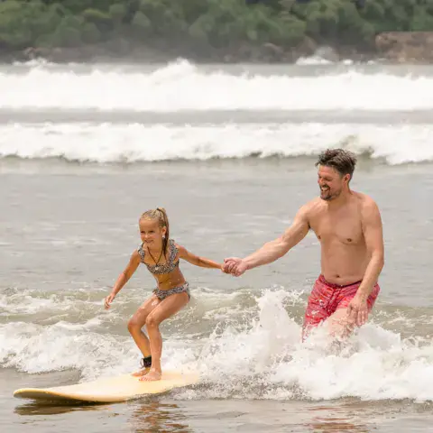 Cours de surf en famille dans les vagues