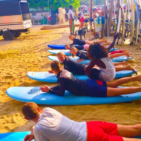Élèves allongés sur leurs planches pour l'exercice de rame