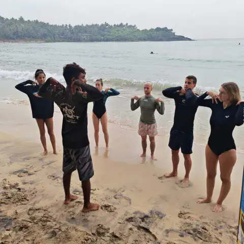 Moniteur et élèves sur la plage de Hiriketiya
