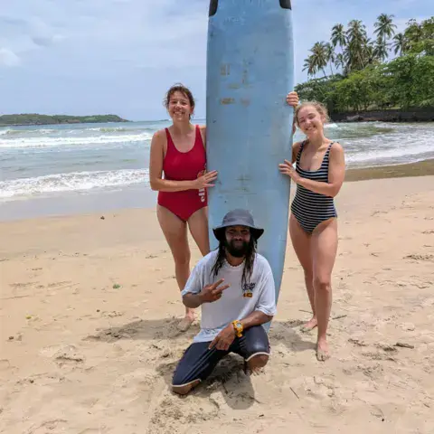 Moniteur et élèves devant une planche sur la plage