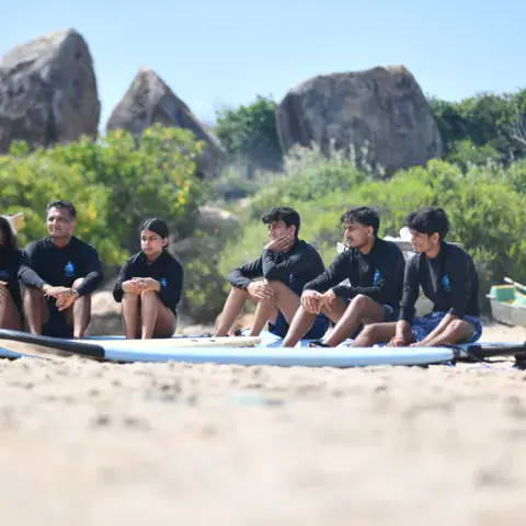 Élèves assis sur la plage près des rochers