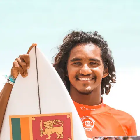 Surfeur avec une planche aux couleurs du Sri Lanka