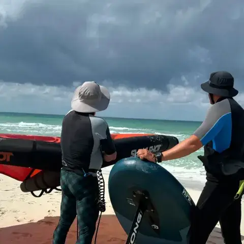 Préparation d'un cours de wing foil sur la plage