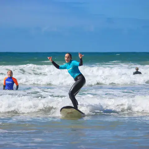 Une élève debout sur sa planche pendant un cours